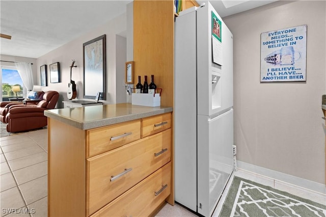 kitchen featuring light tile patterned flooring and white refrigerator with ice dispenser