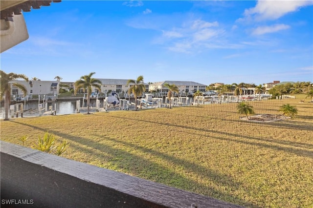 view of yard with a boat dock and a water view