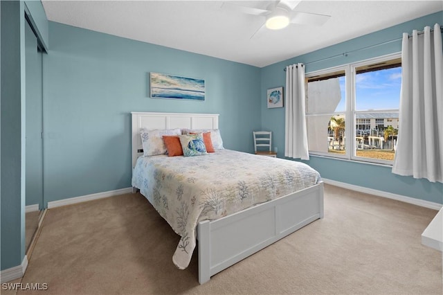 carpeted bedroom featuring ceiling fan and a closet