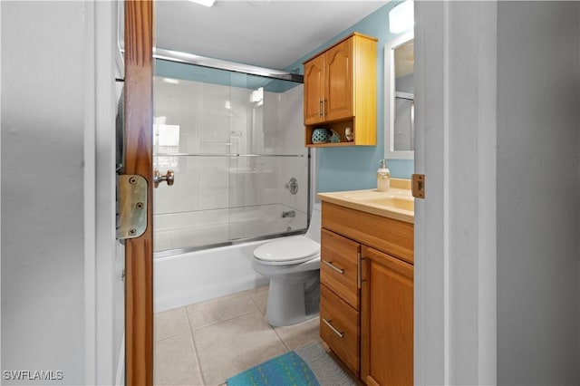 full bathroom featuring toilet, vanity, tile patterned floors, and bath / shower combo with glass door