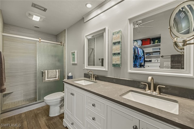 bathroom featuring toilet, vanity, an enclosed shower, and hardwood / wood-style flooring