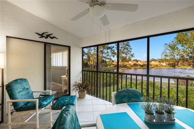 sunroom featuring ceiling fan, a water view, and lofted ceiling