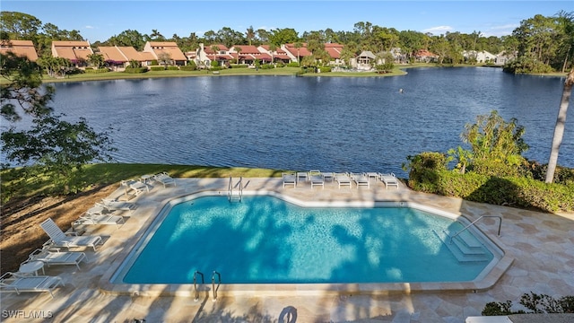 view of swimming pool featuring a water view and a patio