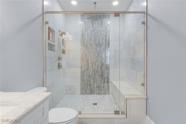 bathroom with an enclosed shower, vanity, and toilet