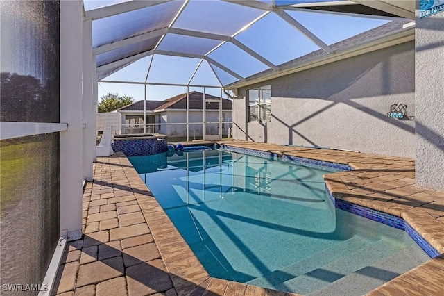 view of swimming pool featuring glass enclosure and a patio