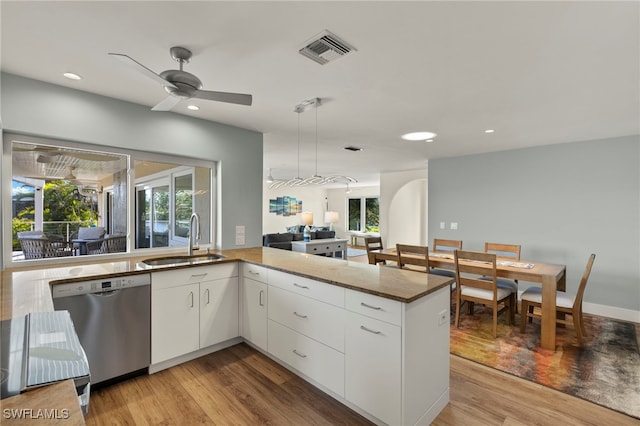 kitchen with white cabinets, kitchen peninsula, dishwasher, and sink