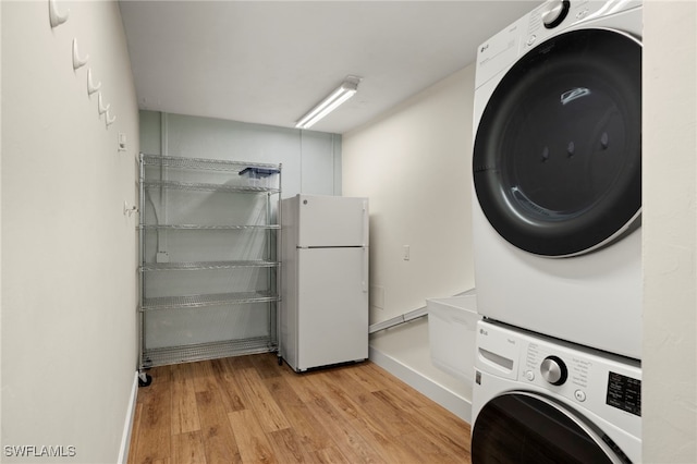 laundry room featuring stacked washer and dryer and light wood-type flooring