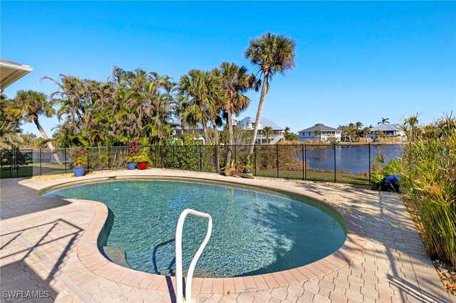 view of swimming pool with a patio area and a water view