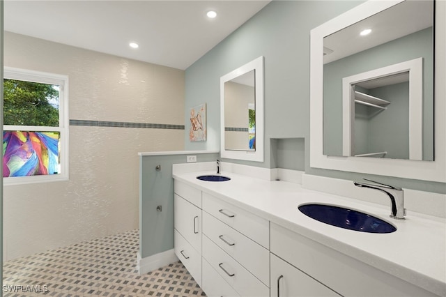 bathroom with a tile shower and vanity