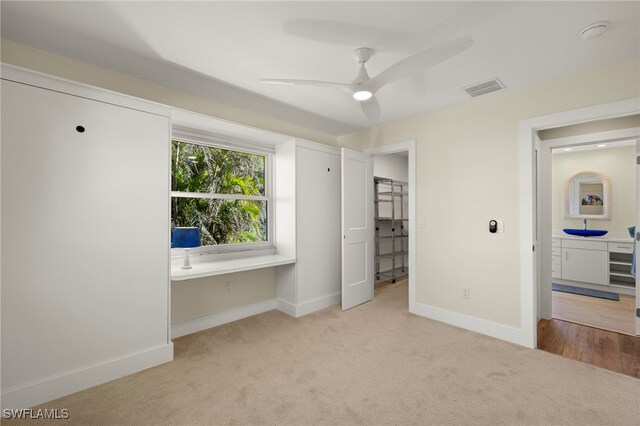 unfurnished bedroom featuring light colored carpet, ceiling fan, and sink