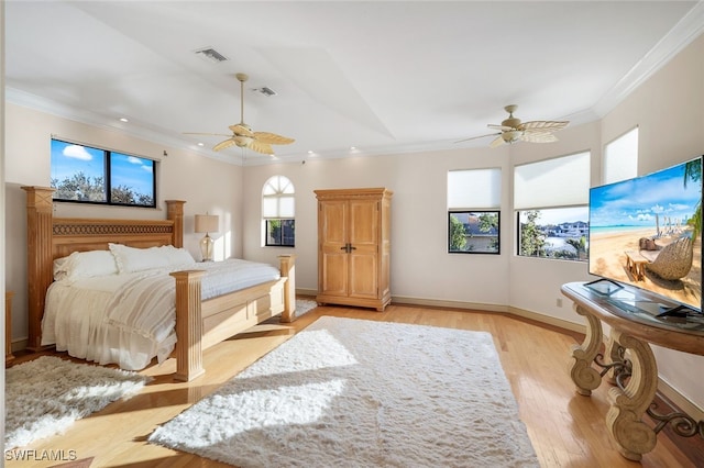 bedroom with ornamental molding, baseboards, visible vents, and light wood finished floors