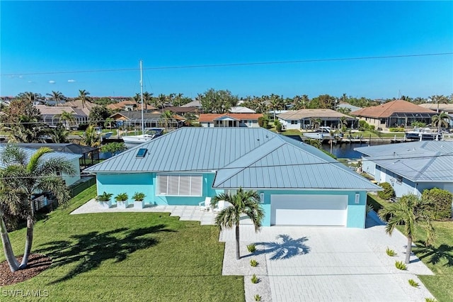 view of front facade with a garage, a water view, and a front lawn