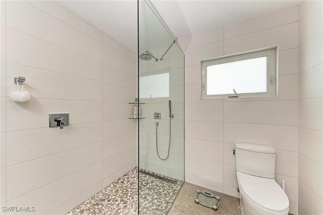 bathroom with toilet and a tile shower