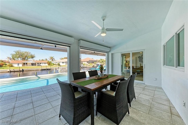 sunroom with ceiling fan, a water view, and lofted ceiling