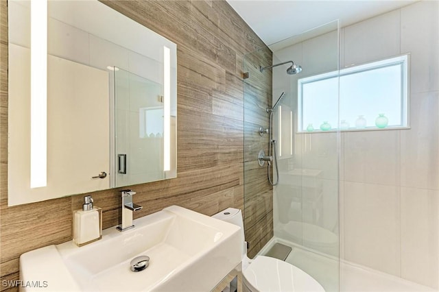 bathroom with sink, tile walls, an enclosed shower, and toilet