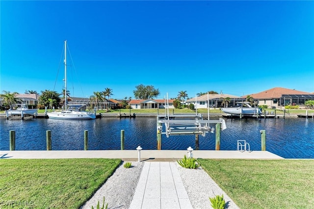 view of dock with a water view and a yard