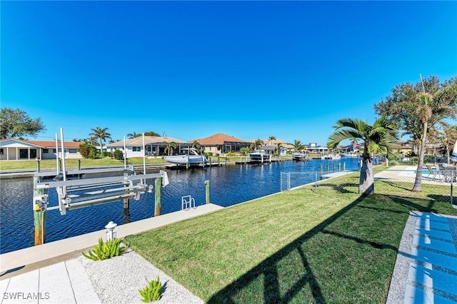 view of dock featuring a lawn and a water view