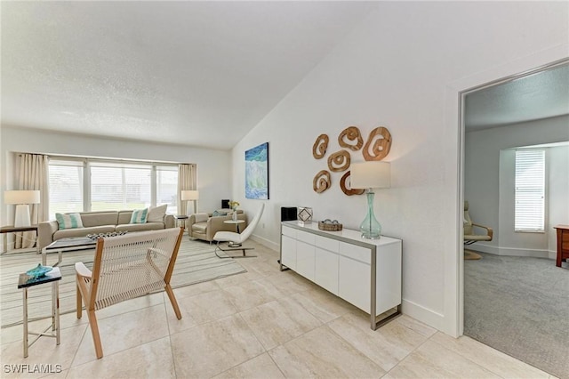 carpeted living room with a textured ceiling and vaulted ceiling