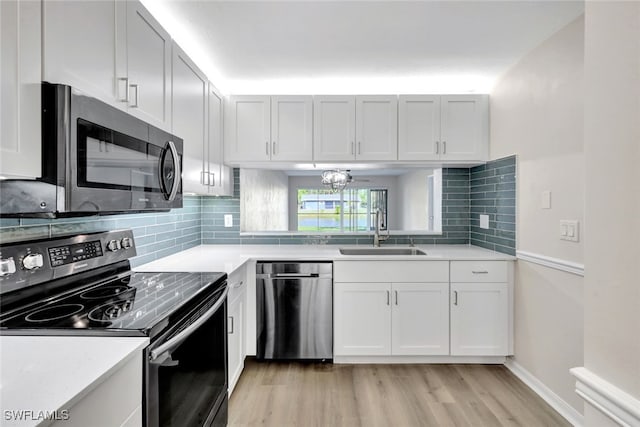 kitchen with stainless steel appliances, white cabinets, decorative backsplash, and sink