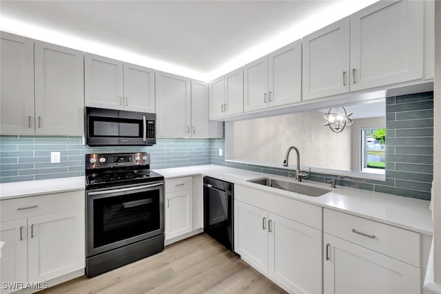 kitchen featuring stainless steel appliances, light hardwood / wood-style floors, backsplash, and sink