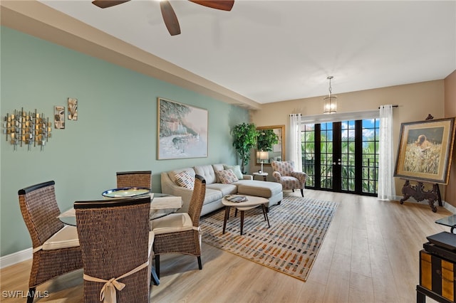 living room with ceiling fan, light hardwood / wood-style flooring, and french doors