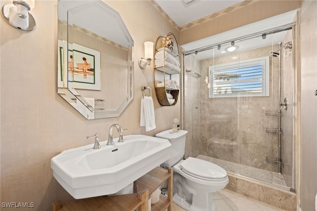 bathroom featuring tile patterned floors, sink, walk in shower, and toilet