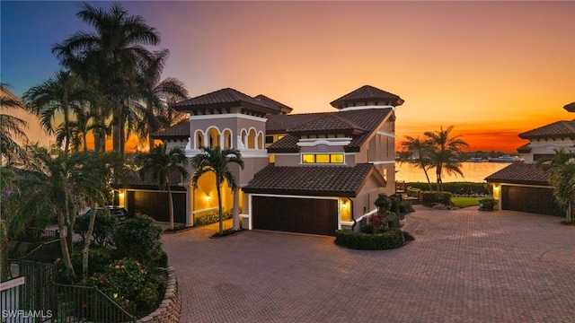 mediterranean / spanish-style house featuring a water view and a garage