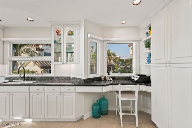 interior space featuring dark stone countertops, white cabinetry, and sink