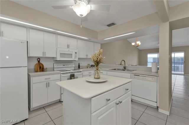 kitchen with light tile patterned floors, sink, white cabinets, and white appliances