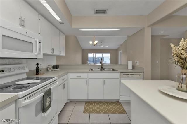 kitchen featuring white appliances, white cabinets, an inviting chandelier, sink, and light tile patterned floors