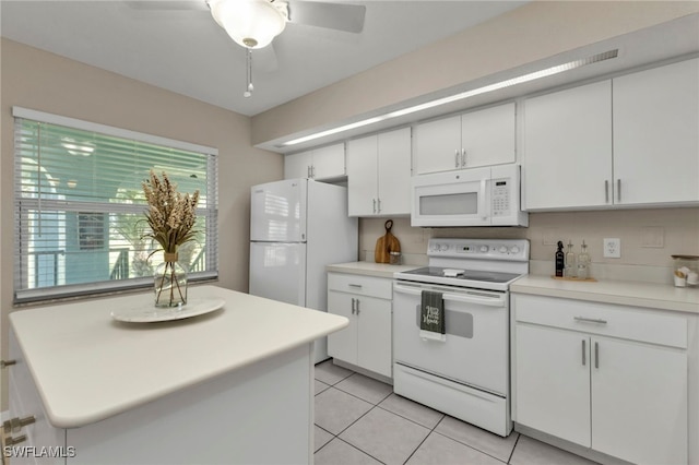 kitchen with backsplash, light tile patterned floors, white appliances, and white cabinets