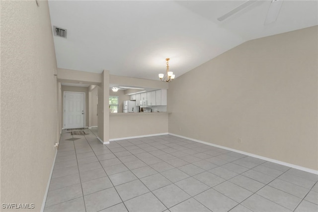 tiled spare room featuring ceiling fan with notable chandelier and lofted ceiling