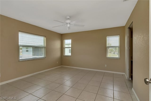 spare room with ceiling fan and light tile patterned floors