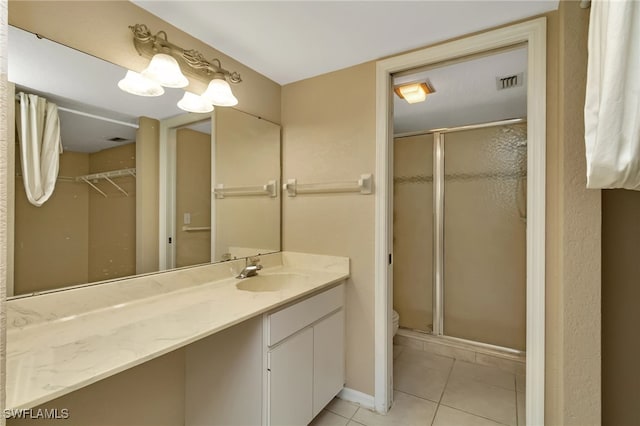 bathroom with toilet, tile patterned floors, a shower with door, and vanity