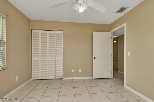 unfurnished bedroom featuring ceiling fan, light tile patterned floors, and a closet