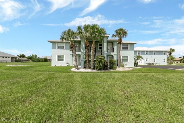 view of front facade with a front lawn and a balcony