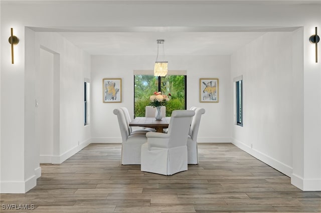 dining area featuring a notable chandelier and light hardwood / wood-style floors