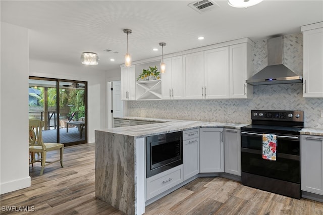 kitchen featuring appliances with stainless steel finishes, light hardwood / wood-style floors, white cabinetry, and wall chimney exhaust hood