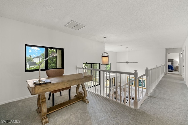 carpeted office featuring ceiling fan and a textured ceiling