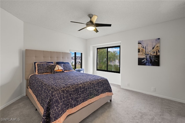 carpeted bedroom with ceiling fan and a textured ceiling