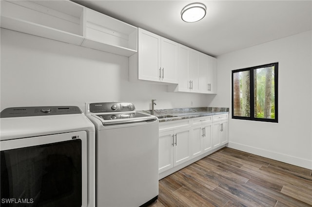 clothes washing area featuring cabinets, sink, separate washer and dryer, and dark wood-type flooring