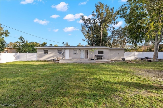 back of property featuring a patio area and a yard