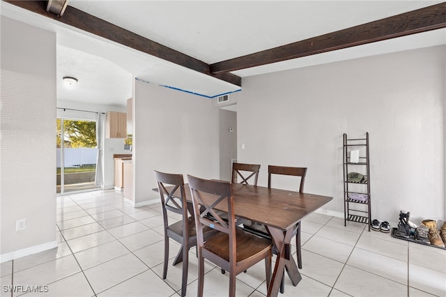 tiled dining room featuring beamed ceiling