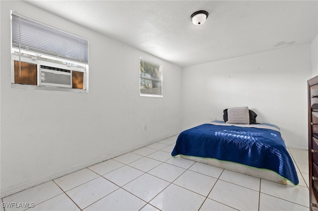 tiled bedroom with a textured ceiling and cooling unit