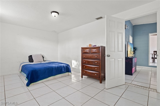 tiled bedroom featuring a textured ceiling