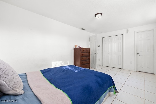 bedroom with a closet and light tile patterned floors