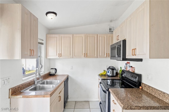 kitchen with lofted ceiling, black appliances, sink, light tile patterned floors, and light brown cabinetry