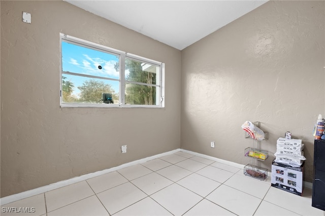 tiled empty room with lofted ceiling