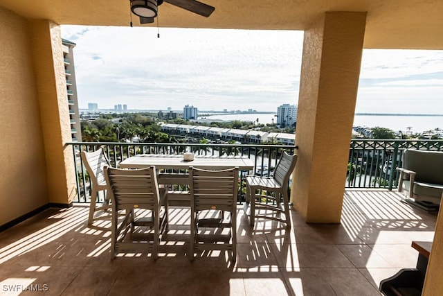 balcony with ceiling fan and a water view