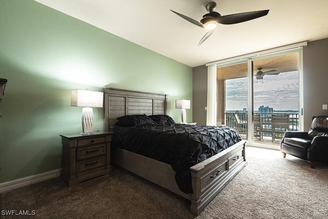 bedroom featuring access to outside, ceiling fan, dark carpet, and a wall of windows